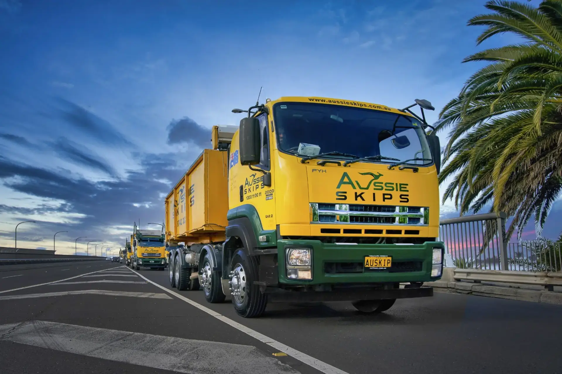 Skip bin truck travelling through a leafy residential area